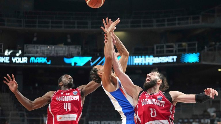 France's Zaccharie Risacher, centre, challenges for the ball with Georgia's Tornike Shengelia, right, and Georgia's Kamar Baldwin during the Eurobasket, European Basketball Championship round of 16 match between France and Georgia at the Riga Arena in Riga, Latvia, Sunday, Sept. 7, 2025. (Sergei Grits/AP)