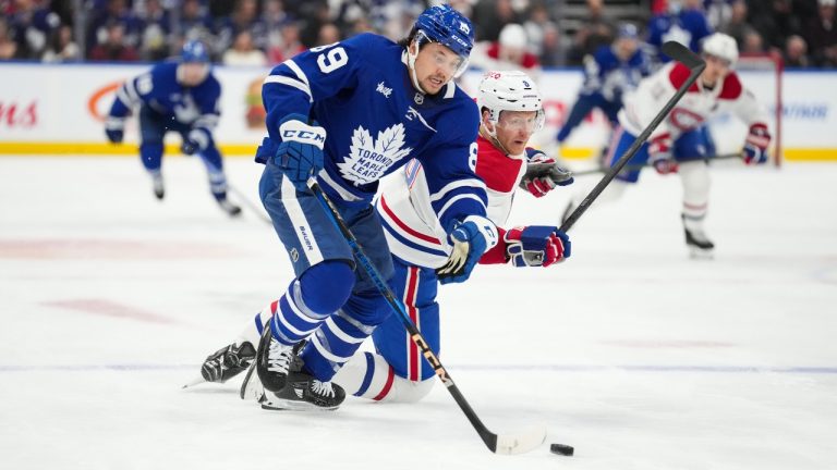 Toronto Maple Leafs' Nicholas Robertson and Montreal Canadiens' Mike Matheson collide while skating after the puck during second period NHL action in Toronto on Saturday, April 12, 2025. (CP/Arlyn McAdorey)
