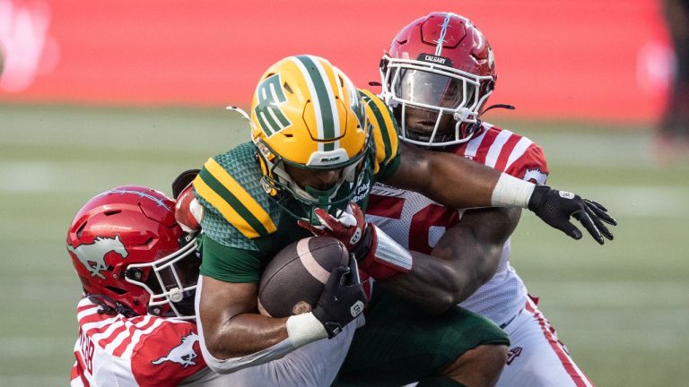 Calgary Stampeders' Damon Webb (9) and Shaun Peterson Jr. (58) tackle Edmonton Elks' Justin Rankin (5) during second half CFL action in Edmonton, Sept. 6, 2025. CP/Jason Franson