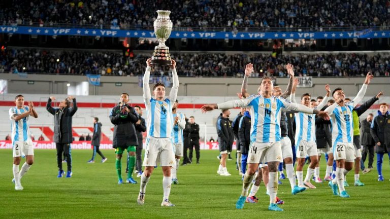 Argentina's Julian Alvarez hoists the 2024 Copa America trophy after a qualifying soccer match for the FIFA World Cup 2026 against Chile in Buenos Aires, Argentina, Thursday, Sept. 5, 2024. (Natacha Pisaren/AP Photo)