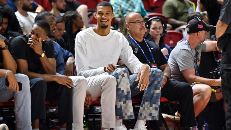 San Antonio Spurs' Victor Wembanyama, centre, sits courtside during the first half of an NBA summer league basketball game between the Spurs and Philadelphia 76ers, July 10, 2025, in Las Vegas. (David Becker/AP)