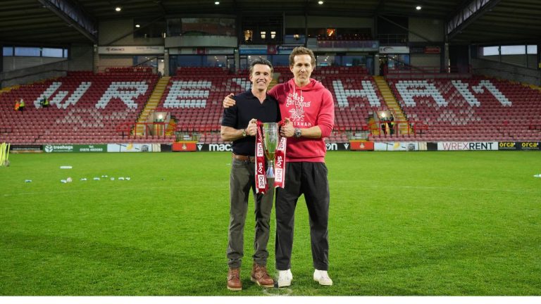 Wrexham co-owners Rob McElhenney, left, and Ryan Reynolds pose with trophy at the end of the English League One soccer match between Wrexham and Charlton Athletic at the Racecourse ground in Wrexham, Wales, Saturday, April 26, 2025. (Jon Super/AP)