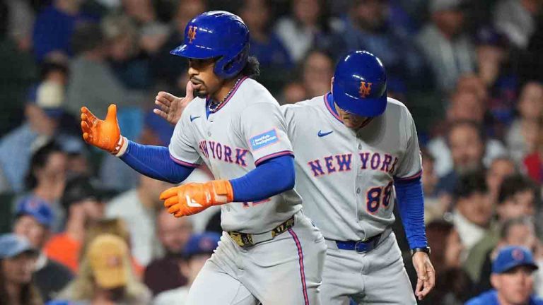 New York Mets' Francisco Lindor, left, is congratulated by third base coach Mike Sarbaugh after hitting a solo home run during the third inning of a baseball game against the Chicago Cubs in Chicago, Thursday, Sept. 25, 2025. (Nam Y. Huh/AP)