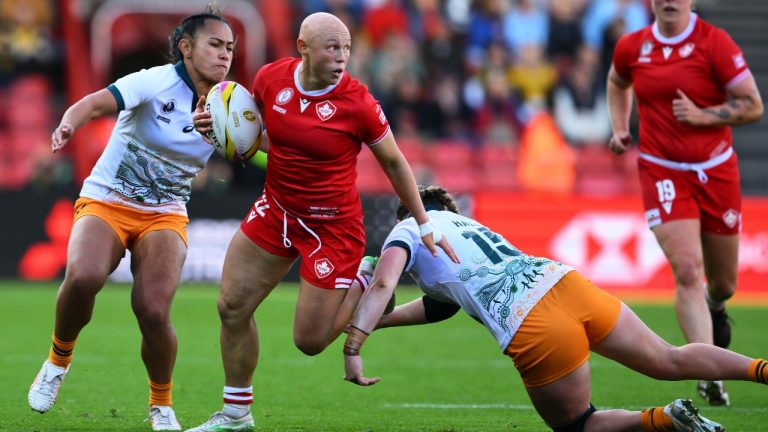 Canada's Olivia Apps, centre, is challenged by Australia's Caitlyn Halse during the Women's Rugby World Cup 2025 quarterfinal match between Canada and Australia, in Bristol, England, Saturday, Sept. 13, 2025. (Anthony Upton/AP)