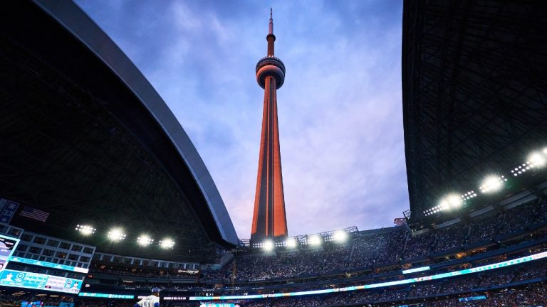 The CN tower is seen through a partially open Rogers Centre dome as the Toronto Blue Jays take on the Minnesota Twins during MLB baseball action in Toronto, on Tuesday, Aug. 26, 2025. (Sammy Kogan/CP)
