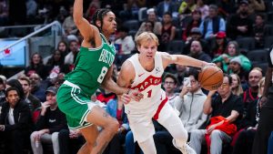 Toronto Raptors guard Gradey Dick drives past Boston Celtics forward Josh Minott during the first half of pre-season NBA action in Toronto Friday, October 10, 2025. (Thomas Skrlj/CP)