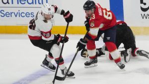Ottawa Senators right wing Claude Giroux (28) and Florida Panthers left wing Brad Marchand (63) go after the puck during the first period of an NHL hockey game, Saturday, Oct. 11, 2025, in Sunrise, Fla. (AP Photo/Marta Lavandier)