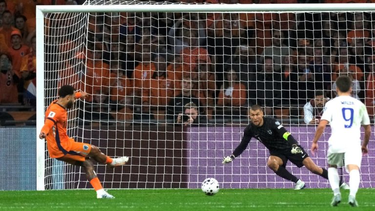 Netherlands' Memphis Depay scores his side's third goal from the penalty spot past Finland goalkeeper Jesse Joronen during a World Cup 2026 group G qualifying soccer match between the Netherlands and Finland in Amsterdam, Sunday, Oct. 12, 2025. (AP Photo/Patrick Post)