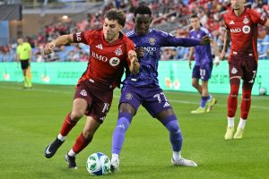 Toronto FC's Kobe Franklin (19) fights for the ball against Orlando City SC's Ivan Angulo during first half MLS soccer action in Toronto on Saturday, Oct. 18, 2025. (Jon Blacker/CP)