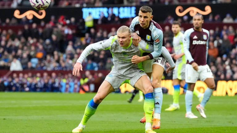 Manchester City's Erling Haaland (left) and Aston Villa's Lucas Digne battle for the ball during the English Premier League match between Aston Villa and Manchester City, in Birmingham, England, Sunday Oct. 26, 2025. (Nick Potts/PA via AP)