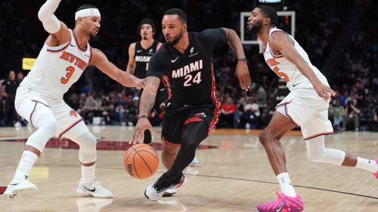 Miami Heat guard Norman Powell drives between New York Knicks guard Josh Hart and guard Mikal Bridges during an NBA game, Sunday, Oct. 26, 2025, in Miami. (Rebecca Blackwell/AP)