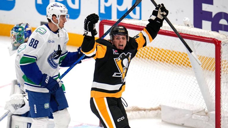 Pittsburgh Penguins' Blake Lizotte, right, celebrates a goal by Connor Dewar, with Vancouver Canucks' Nils Aman (88) defending during the first period of an NHL hockey game in Pittsburgh, Tuesday, Oct. 21, 2025. (Gene J. Puskar/AP