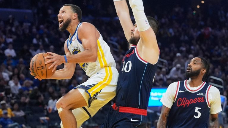Golden State Warriors guard Stephen Curry, left, shoots against Los Angeles Clippers center Ivica Zubac, middle, and forward Derrick Jones Jr. (5) during the second half of an NBA basketball game in San Francisco, Tuesday, Oct. 28, 2025. (Jeff Chiu/AP)