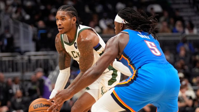 Milwaukee Bucks guard Kevin Porter Jr., left, handles the ball against Oklahoma City Thunder guard Luguentz Dort (5) during the first half of a preseason NBA basketball game Tuesday, Oct. 14, 2025, in Milwaukee. (AP Photo/Kayla Wolf)