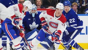 Montreal Canadiens' Lane Hutson (48) and Juraj Slafkovsky (20) work for the puck as Toronto Maple Leafs goaltender Anthony Stolarz (41) and Jake McCabe (22) look on during second period NHL hockey action in Toronto on Wednesday, Oct. 8, 2025. (Frank Gunn/CP)