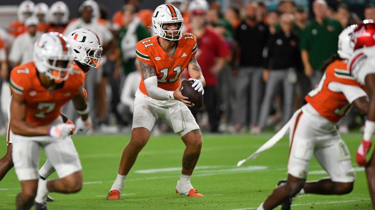 Miami quarterback Carson Beck (11) receives the ball during the first half of an NCAA college football game against Louisville, Friday, Oct. 17, 2025, in Miami Gardens, Fla. (AP Photo/Michael Laughlin)