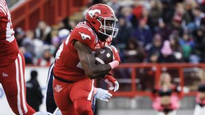 Toronto Argonauts' Cameron Judge, left, grabs for Calgary Stampeders' Dedrick Mills during first half CFL action in Calgary, Saturday, Oct. 18, 2025. (THE CANADIAN PRESS/Jeff McIntosh)