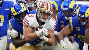 San Francisco 49ers running back Christian McCaffrey, middle, is tackled by Los Angeles Rams linebacker Byron Young, left, during the first half of an NFL football game, Thursday, Oct. 2, 2025, in Inglewood, Calif. (AP Photo/Marcio Jose Sanchez)
