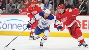 Edmonton Oilers center Connor McDavid, front left, and Detroit Red Wings center Emmitt Finnie, right, vie for the puck during the first period of an NHL hockey game Sunday, Oct. 19, 2025, in Detroit. (AP Photo/Ryan Sun)