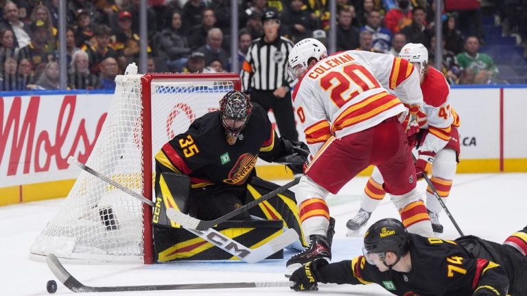Vancouver Canucks goalie Thatcher Demko (35) watches as Jake DeBrusk (74) swats the puck away from Calgary Flames' Blake Coleman (20) during the second period of an NHL hockey game in Vancouver, on October 9, 2025. (Darryl Dyck/ CP)