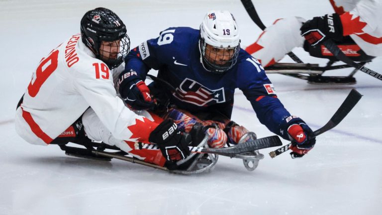 Team USA forward Malik Jones (19) is checked by Team Canada forward Dominic Cozzolino (19) during second period action in the World Para Ice Hockey Championship final in Calgary, May 12, 2024. (Jeff McIntosh/CP)