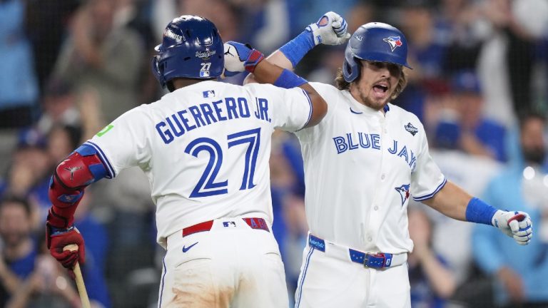 Toronto Blue Jays' Addison Barger, right, celebrates after hitting a grand slam with Vladimir Guerrero Jr. during sixth inning Game 1 World Series playoff MLB baseball action against the Los Angeles Dodgers in Toronto on Friday, Oct. 24, 2025. (Nathan Denette/CP)
