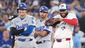 Los Angeles Dodgers' Shohei Ohtani (17) and Toronto Blue Jays first baseman Vladimir Guerrero Jr. (27) smile as they look on during a review of a pick off attempt during ninth inning Game 1 World Series playoff MLB baseball action in Toronto on Friday, Oct. 24, 2025. (Nathan Denette/CP)