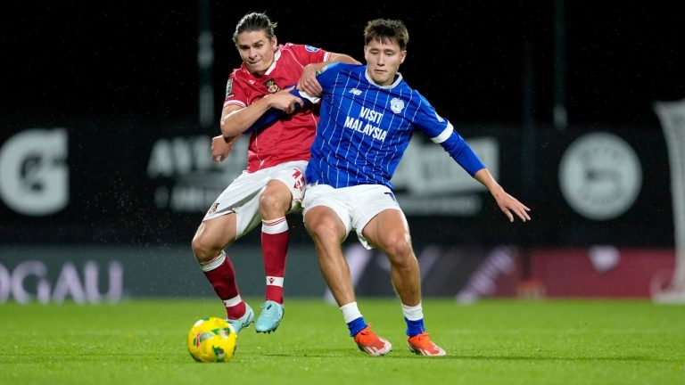 Wrexham's George Dobson, left, and Cardiff City's Rubin Colwill battle for the ball during the English League Cup fourth round soccer match between Wrexham and Cardiff City in Wrexham, Wales, Tuesday Oct. 28, 2025. (Peter Byrne/PA via AP)