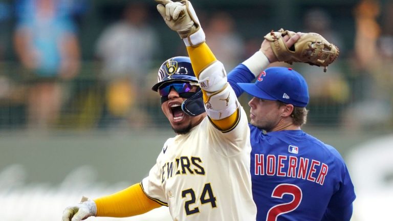 Milwaukee Brewers' William Contreras (24) reacts to hitting an RBI double allowing Brice Turang to score as Chicago Cubs second baseman Nico Hoerner (2) catches a late throw during the first inning in Game 1 of baseball's National League Division Series game Saturday, Oct. 4, 2025, in Milwaukee. (Kayla Wolf/AP)