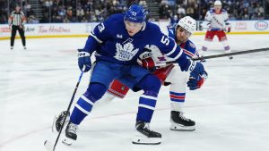 Toronto Maple Leafs' Easton Cowan (53) protects the puck from New York Rangers' Matthew Robertson (29) during second period NHL hockey action in Toronto on Thursday, October 16, 2025. (Nathan Denette/CP)