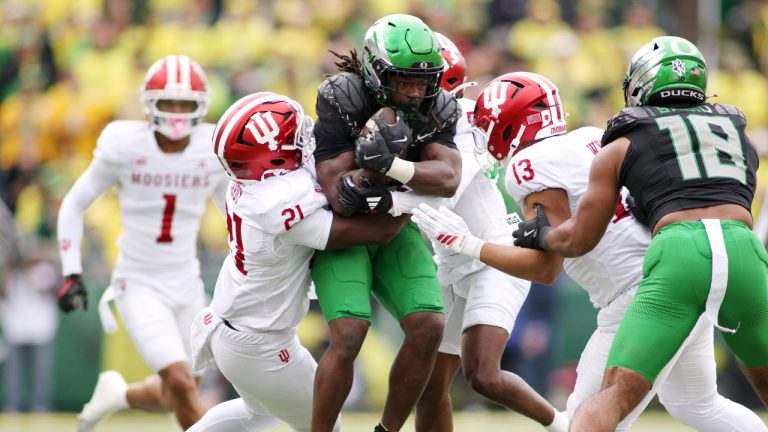 Oregon running back Noah Whittington, center, attempts to break a tackleby Indiana linebacker Rolijah Hardy (21), defensive back D'Angelo Ponds (5) and linebacker Kellan Wyatt (13) during the first half of an NCAA college football game, Saturday, Oct. 11, 2025, in Eugene, Ore. (Lydia Ely/AP Photo)