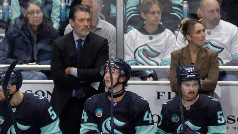 Seattle Kraken head coach Lane Lambert, left, and assistant coach Jessica Campbell, right, watch from the bench during the third period of a preseason NHL hockey game Sunday, Sept. 21, 2025, in Seattle. (John Froschauer/AP)