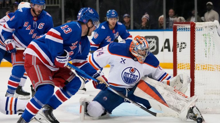 Edmonton Oilers goaltender Stuart Skinner (74) protects the net from New York Rangers' Alexis Lafrenière (13) during the second period of an NHL hockey game Tuesday, Oct. 14, 2025, in New York. (Frank Franklin II/AP)