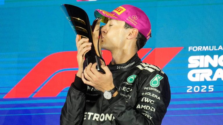 Mercedes driver George Russell of Britain kisses his trophy as he celebrates after winning the Singapore Formula One Grand Prix at the Marina Bay Street Circuit in Singapore, Sunday, Oct. 5, 2025. (Vincent Thian/AP)