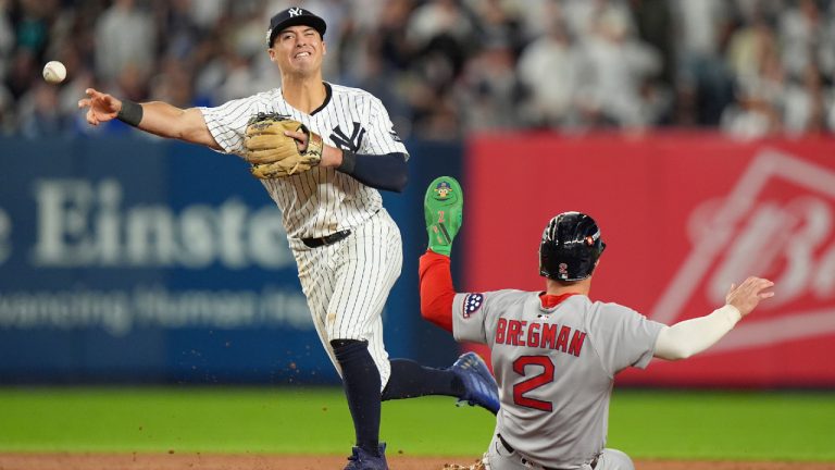 New York Yankees shortstop Anthony Volpe makes the throw to first for a double play as Boston Red Sox Alex Bregman (2) slides during the eighth inning of Game 2 of an American League wild-card baseball playoff series, Wednesday, Oct. 1, 2025, in New York. (Frank Franklin II/AP)