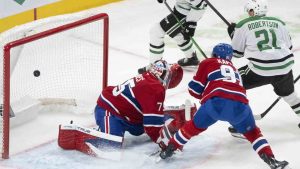 Dallas Stars' Jason Robertson (21) scores on Montreal Canadiens goaltender Jakub Dobes (75) as Canadiens' Oliver Kapanen (91) tries to defend during second period NHL hockey action in Montreal on Thursday, Nov. 13, 2025. (Christinne Muschi/CP)