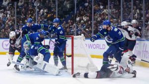 Vancouver Canucks' Marcus Pettersson (29) checks Columbus Blue Jackets' Adam Fantilli, bottom right, to the ice as Vancouver's goalie Kevin Lankinen (32) looks for the rebound while Evander Kane (91), Tyler Myers (57) and Elias Pettersson (40) defend against Columbus' Kirill Marchenko (86) during the first period of an NHL hockey game in Vancouver, on Saturday, November 8, 2025. (Darryl Dyck/CP)
