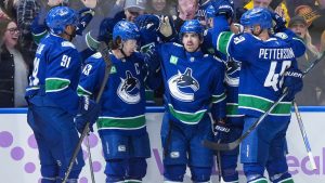 Vancouver Canucks' Evander Kane, Quinn Hughes, Conor Garland, Tyler Myers and Elias Pettersson celebrate during the third period of an NHL game against the Columbus Blue Jackets, in Vancouver, on Saturday, November 8, 2025. (Darryl Dyck/CP)