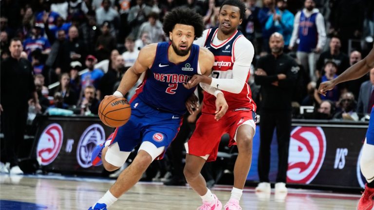 Detroit Pistons guard Cade Cunningham, left, drives against Washington Wizards guard Bub Carrington during overtime in an NBA basketball game Monday, Nov. 10, 2025, in Detroit. (AP Photo/Ryan Sun)