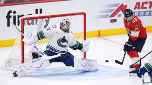 Vancouver Canucks goaltender Jiri Patera, left, fails to stop a shot by Florida Panthers defenceman Seth Jones (not shown) for the team's seventh goal while under pressure from Panthers left wing Brad Marchand (63) during the third period of an NHL hockey game, Monday, Nov. 17, 2025, in Sunrise, Fla. (Rebecca Blackwell/AP)