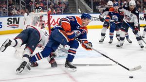 Columbus Blue Jackets' Luca Del Bel Belluz (65) hits the net while chasing Edmonton Oilers' Connor McDavid (97) during second period NHL action, in Edmonton, Monday, Nov. 10, 2025. (Jason Franson/CP)