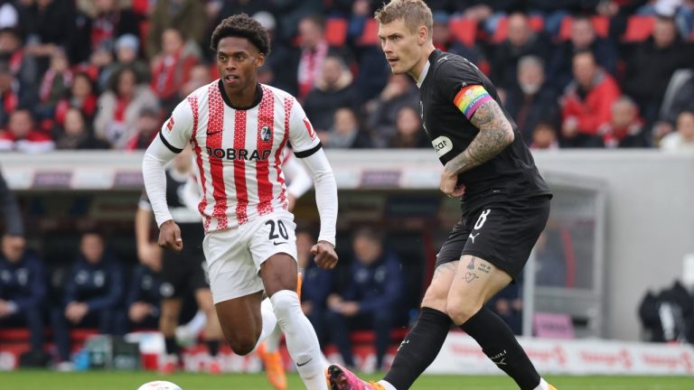 Freiburg's Junior Adamu, left, and St. Pauli's Eric Smith, right, challenge for the ball during the German Bundesliga soccer match between SC Freiburg and FC St. Pauli in Freiburg, Germany, Sunday, Nov. 9, 2025. (Philipp von Ditfurth/dpa via AP)