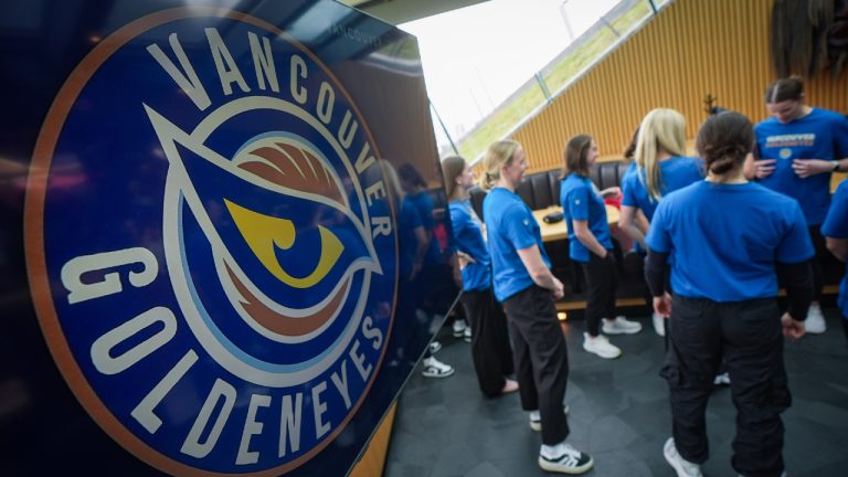Vancouver Goldeneyes PWHL hockey team players stand near a display showing their logo after the team name and logo was unveiled during an event, in Vancouver, B.C., Thursday, Nov. 6, 2025. (Darryl Dyck/CP)