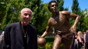Former NBA basketball player and coach Lenny Wilkens poses for a photo with his statue after its unveiling outside of Climate Pledge Arena, Saturday, June 28, 2025, in Seattle. (AP Photo/Lindsey Wasson)