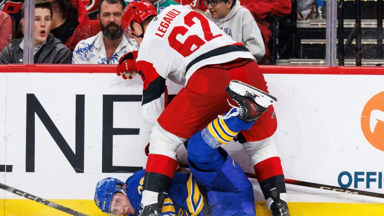 Buffalo Sabres Jack Quinn is knocked to the ice by Carolina Hurricanes Charles Alexis Legault (62) during the third period of an NHL hockey game. (Ben McKeown/AP)