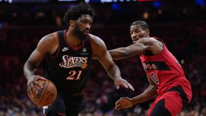 Philadelphia 76ers' Joel Embiid, left, tries to get past Toronto Raptors' Ochai Agbaji during the first half of an NBA basketball game Saturday, Nov. 8, 2025, in Philadelphia. (AP Photo/Matt Slocum)