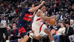 Toronto Raptors forward Scottie Barnes (4) drives past Washington Wizards forward Kyshawn George (18) during first half NBA basketball action in Toronto, Monday, March 10, 2025. THE CANADIAN PRESS/Nathan Denette