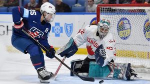 Canada goalie Kayle Osborne, right, stops a shot by United States forward Alex Carpenter during the third period of a Rivalry Series women's hockey game, Saturday, Nov. 8, 2025, in Buffalo, N.Y. (AP Photo/Adrian Kraus)
