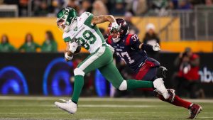 Saskatchewan Roughriders' Kian Schaffer-Baker (89) runs the ball as Montreal Alouettes' Wesley Sutton (37) attempts a tackle during first half CFL football action at the 112th Grey Cup, in Winnipeg on Sunday, Nov. 16, 2025. (Darryl Dyck/CP)