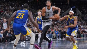 San Antonio Spurs forward Victor Wembanyama (1) drives against Golden State Warriors forward Draymond Green (23) during the first half of an NBA Cup basketball game in San Antonio, Friday, Nov. 14, 2025. (AP Photo/Eric Gay)